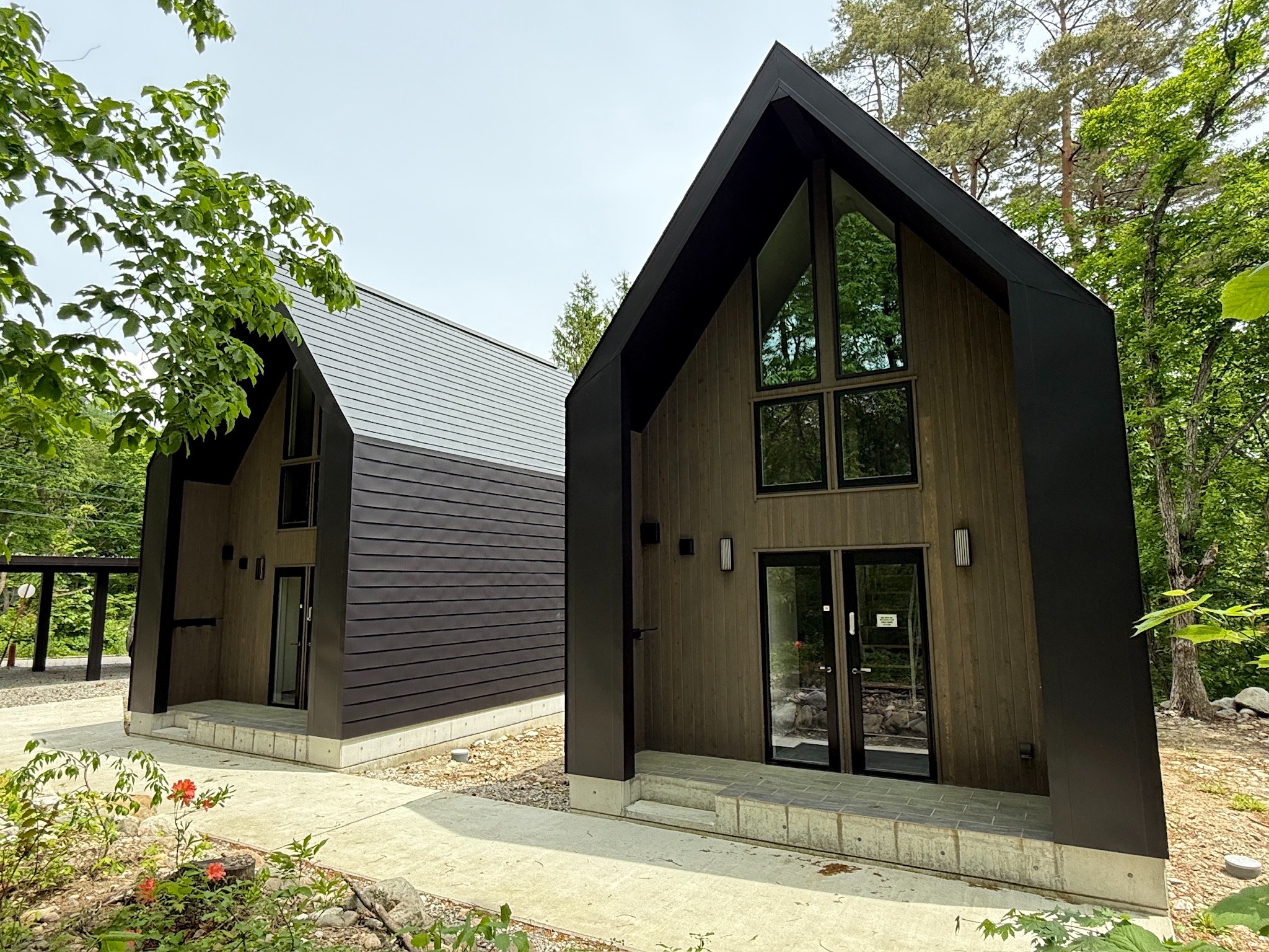 Two Summit Chalets surrounded by trees in Hakuba